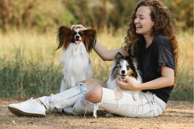 girl-playing-with-two-dogs